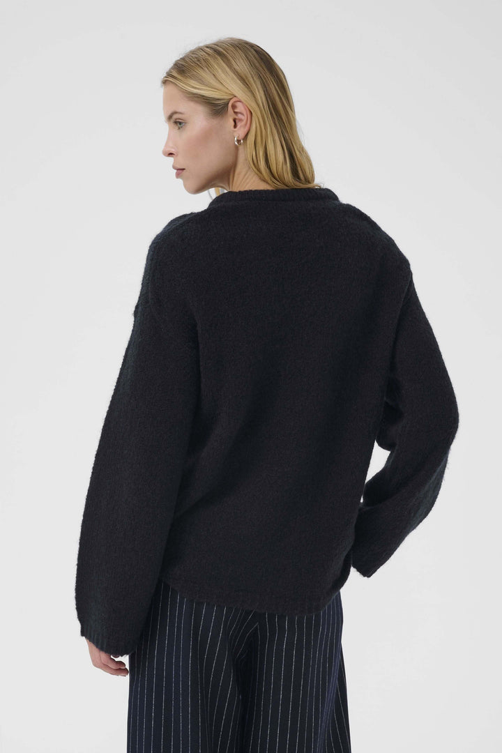 Tricot Spence noir avec col rond classique, manches longues et coupe droite, idéal pour un look décontracté chic.
