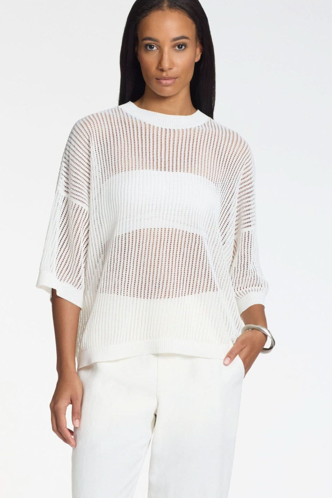 Femme portant un tricot ajouré en maille légère manches 3/4, coupe fluide, parfait pour un style moderne et respirant.