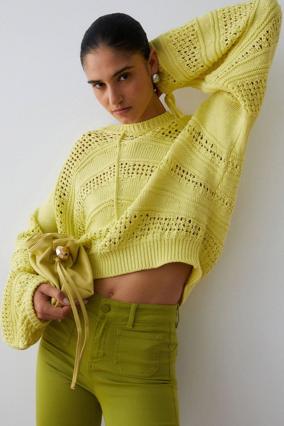 Femme portant un Tricot ajouré à manches longues avec une coupe moderne et légère, idéal pour la mi-saison.