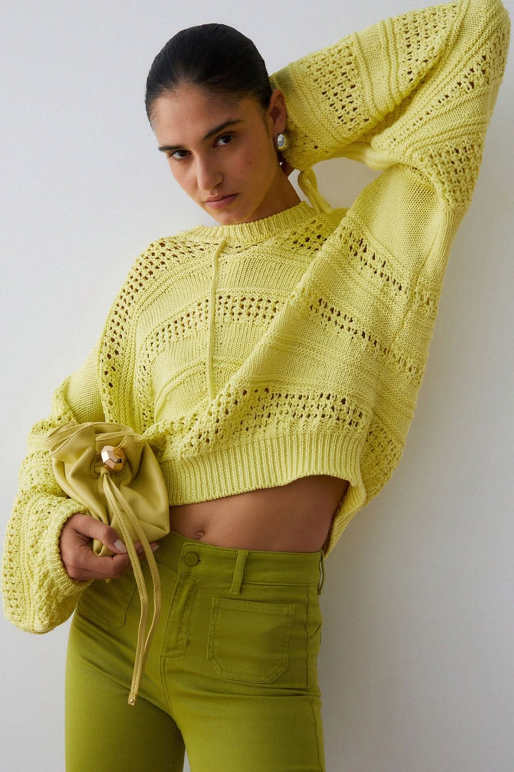 Femme portant un Tricot ajouré à manches longues avec une coupe moderne et légère, idéal pour la mi-saison.