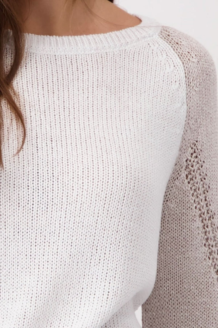 Close-up of a stylish color block tricot pullover featuring metallic finish and modern design details.