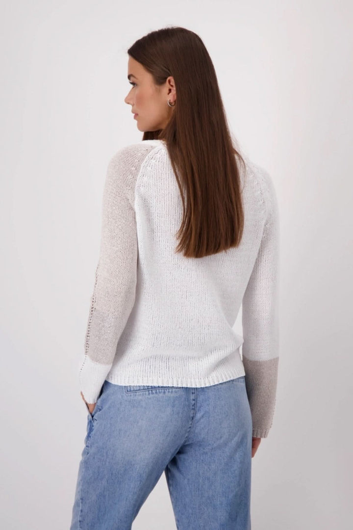 Back view of a woman wearing a color block tricot pullover with long sleeves and a modern design.
