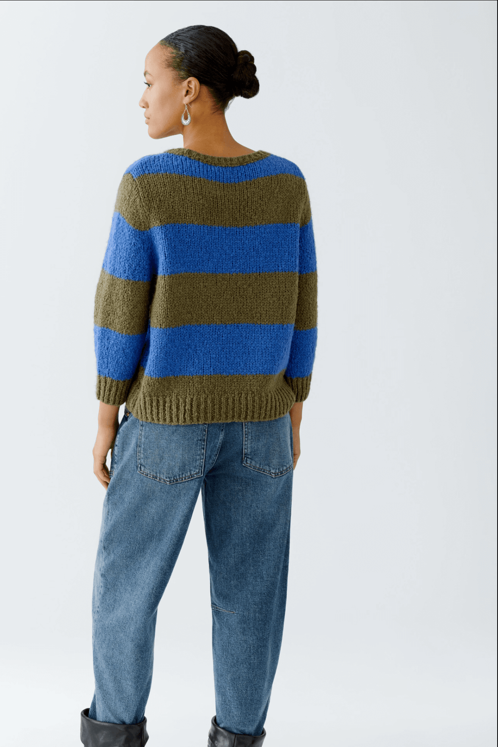 Tricot rayures larges en laine et mohair avec manches 3/4, coupe décontractée et col ras du cou, porté avec un jean.