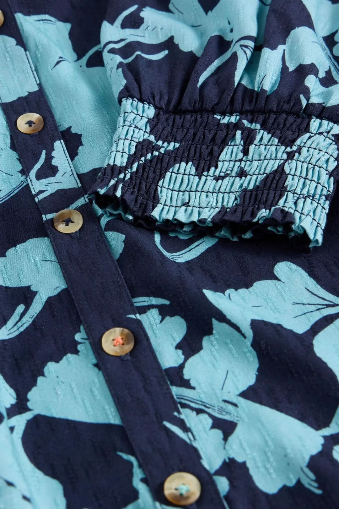 Close-up of Tunique Amy's botanical print and textured sleeves, showcasing its comfortable and stylish design.