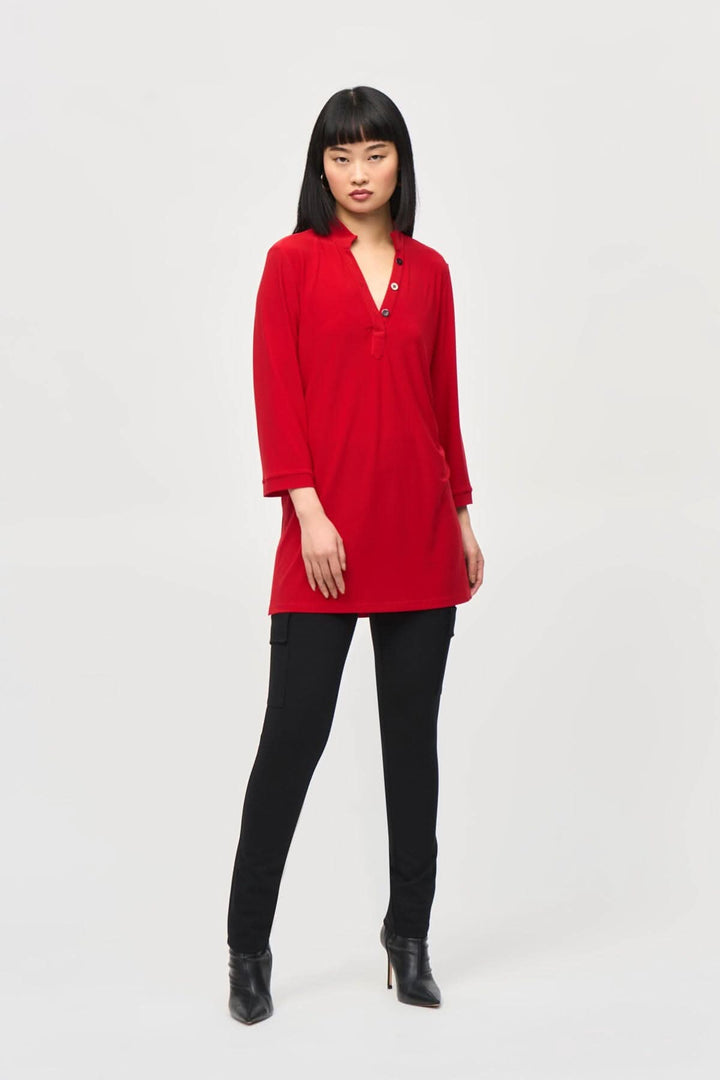 Tunique confortable rouge encolure en V avec boutons, manches 3/4, portée sur un pantalon noir.