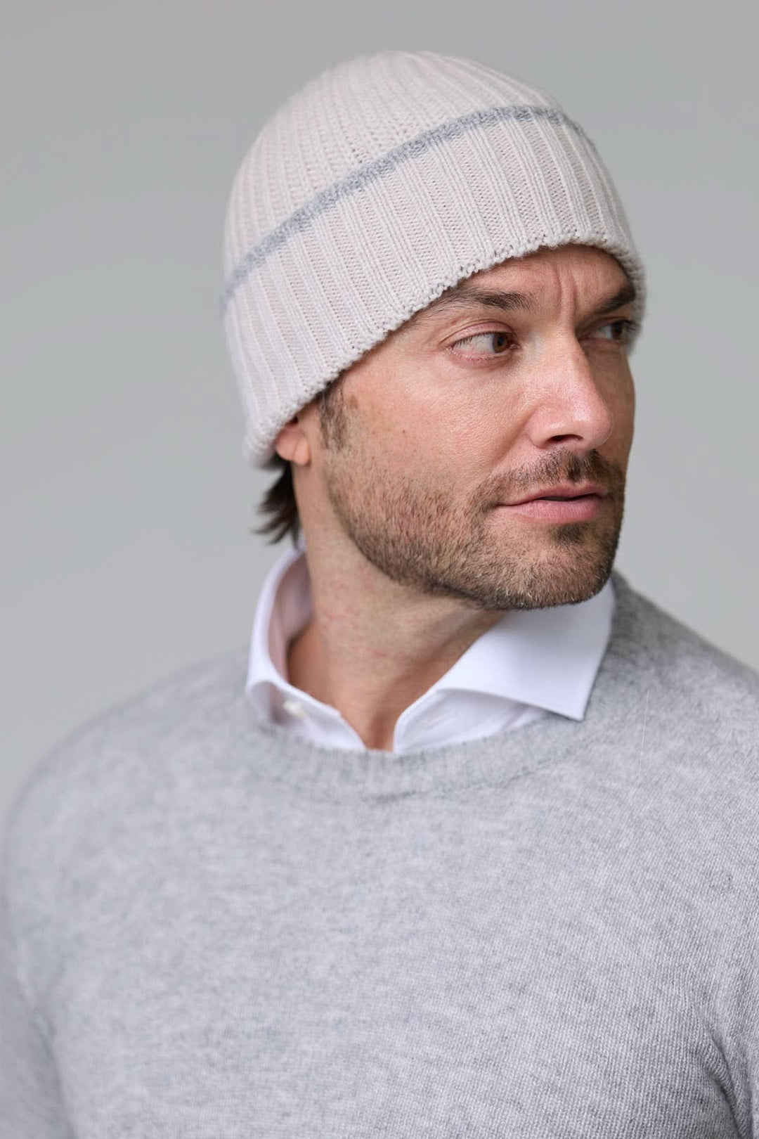 Homme portant une tuque en tricot côtelé blanche, style décontracté et chaud pour l'hiver.