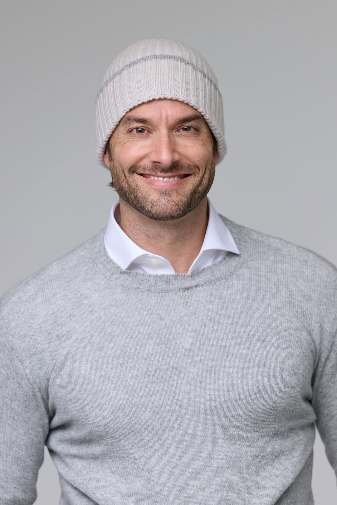 Homme portant une tuque en tricot côtelé grise pour affronter le froid avec style et confort.