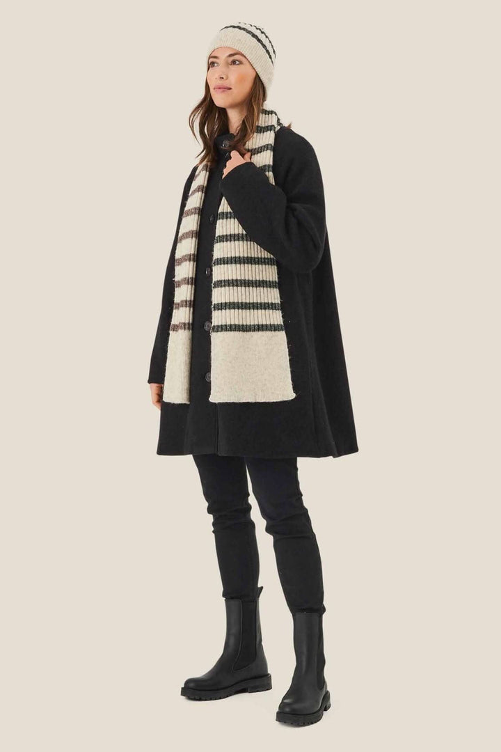 Femme portant une tuque lignée et une écharpe rayée, vêtue d&