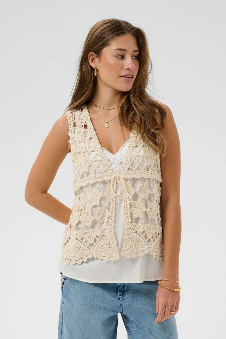 Veste Lotu sans manches en crochet sur mannequin, motif floral ajouré, parfaite pour un style bohème et élégant.