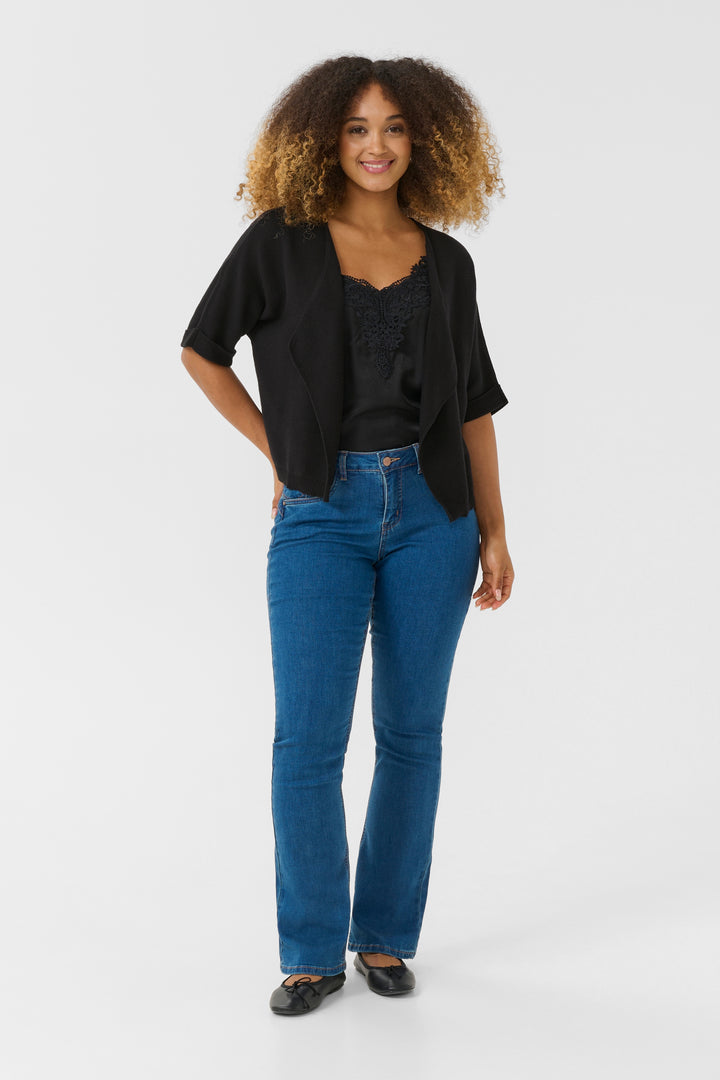 Femme portant la Veste avec manches Sillar noire avec un chemisier et un jean, illustrant un style décontracté mais élégant.