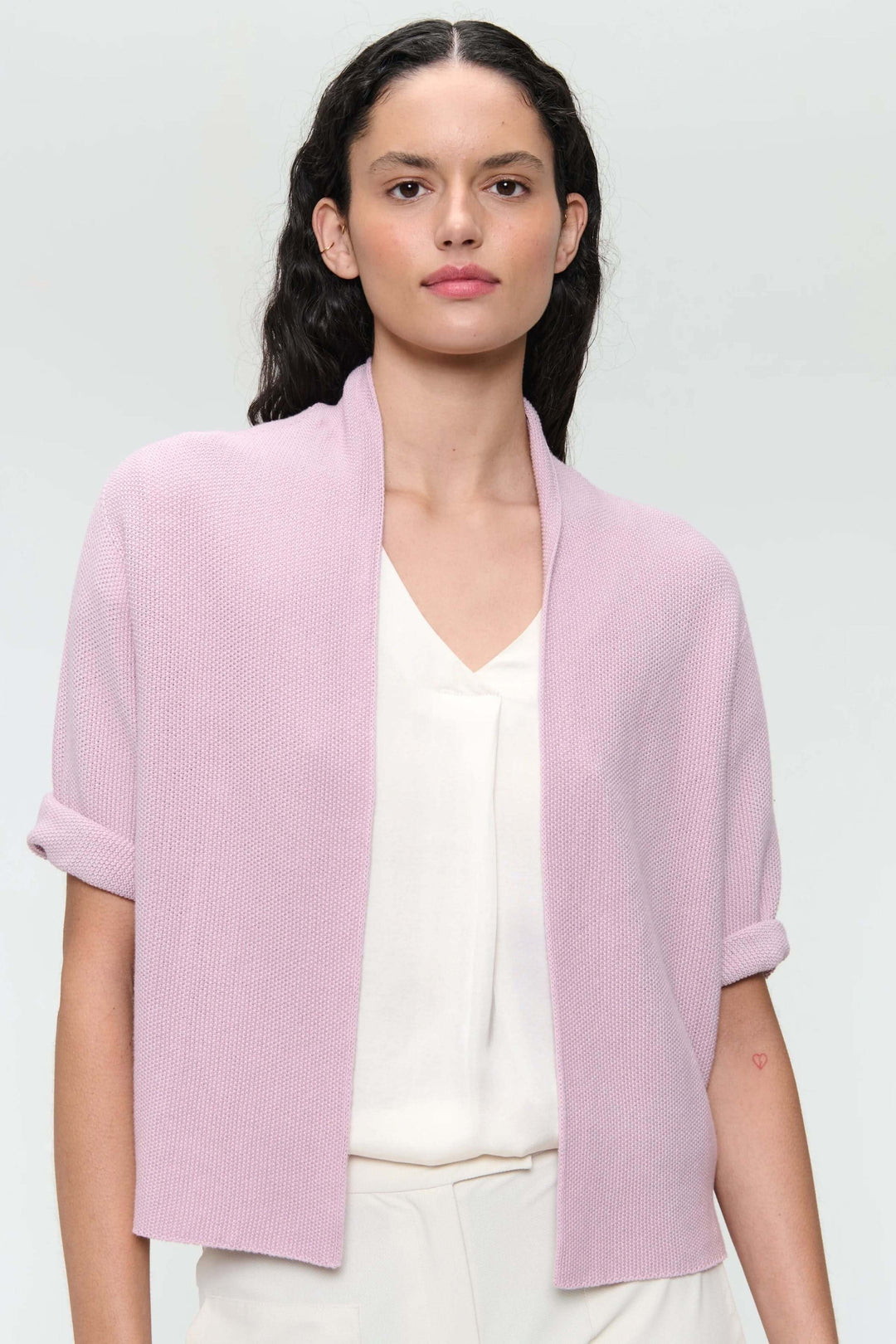 Veste sans manches en tricot texturé, coupe droite, couleur rose clair, idéale pour un style décontracté-chic.