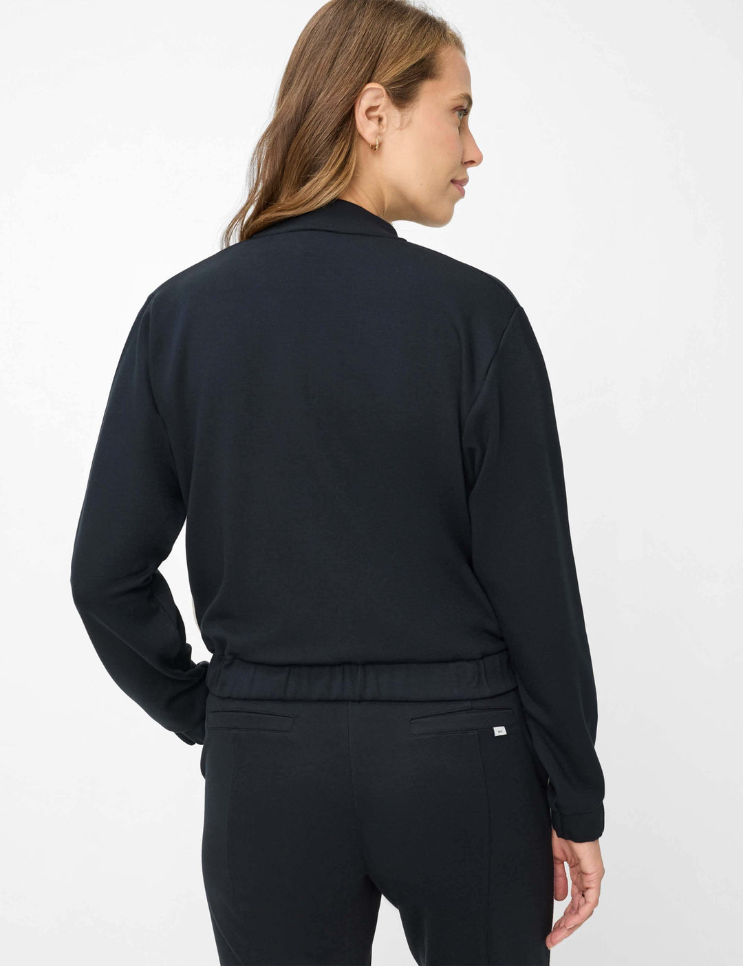 Vue arrière de la Veste bomber zipée BECKY L. en noir, illustrant sa structure minimaliste et contemporaine.