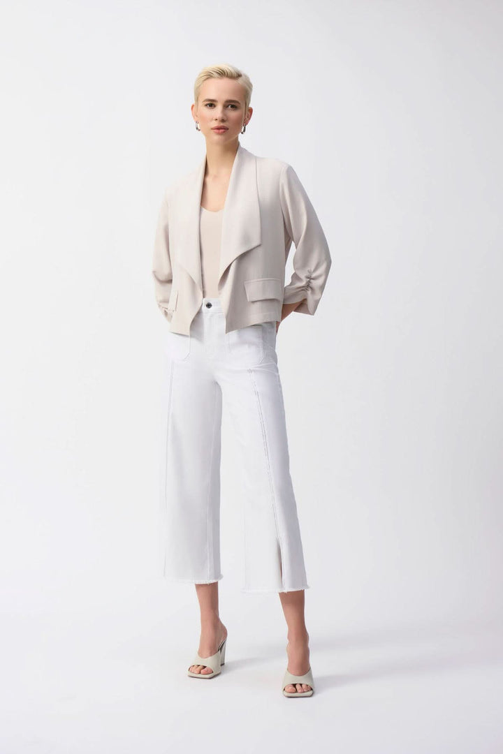 Veste col châle en tricot beige avec pantalon blanc, look décontracté et élégant, mannequin présentant le produit.