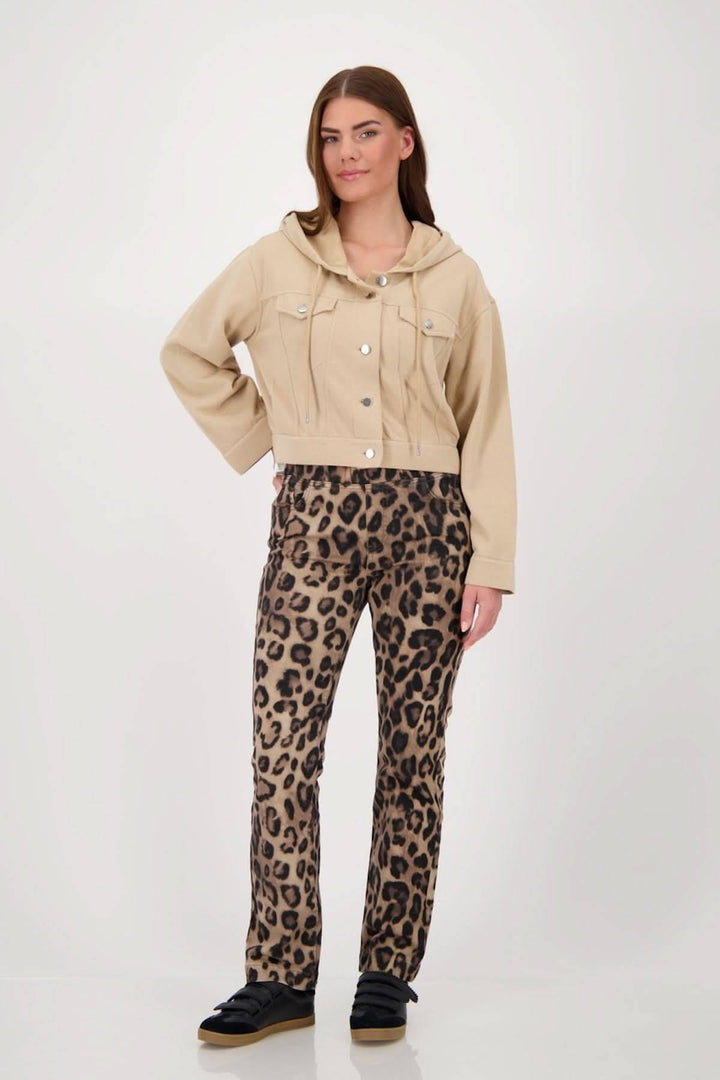 Modèle portant une veste courte à capuchon beige avec des poches, assortie à un pantalon léopard, style décontracté.