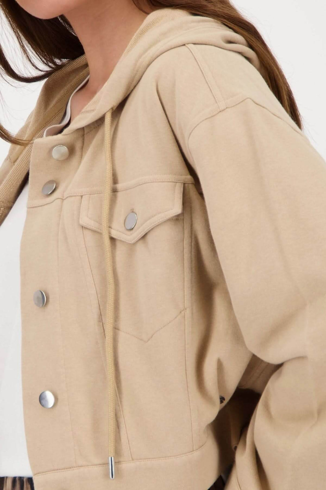 Veste courte à capuchon beige avec poches, coupée boxy et cordon ajustable, parfaite pour un look décontracté.