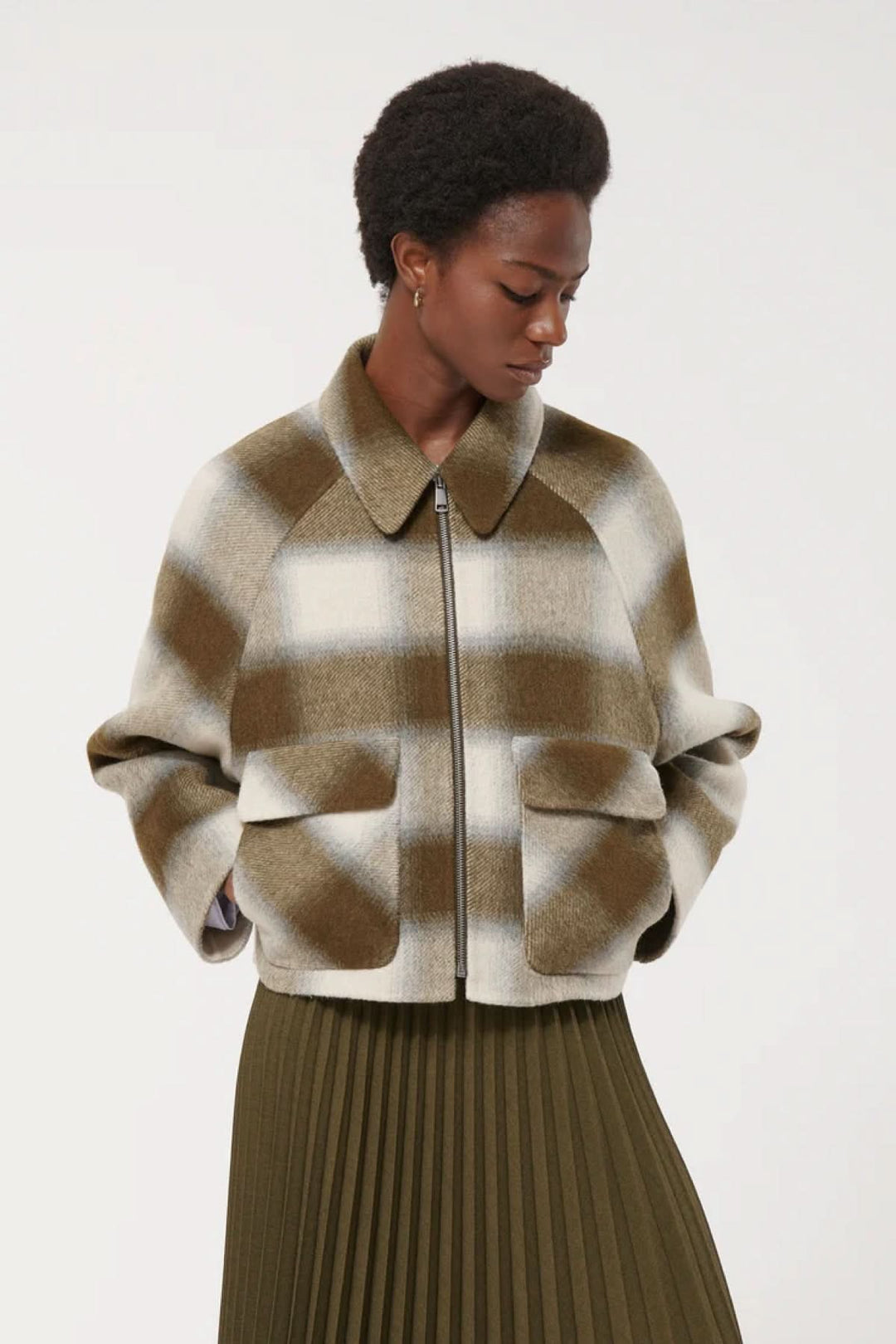 Veste courte à carreaux pour un style moderne avec poches à rabat, parfaite pour l'automne, portée par une femme.