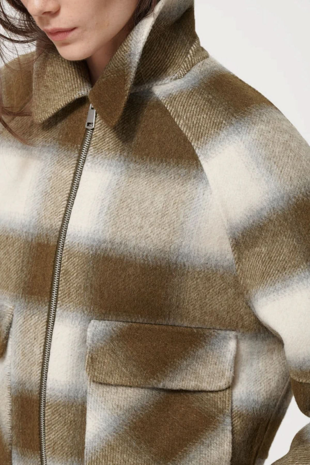 Veste courte à carreaux moderne avec poche à rabat et fermeture éclair, idéale pour superpositions automnales raffinées.