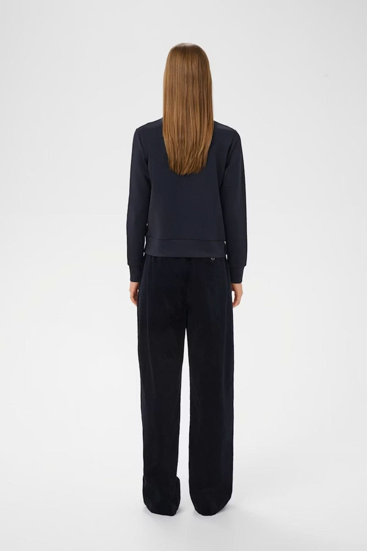 Veste à manches longues Beca de dos, coupe régulière, avec fermeture éclair et poches poitrine, style chic et urbain, femme debout.