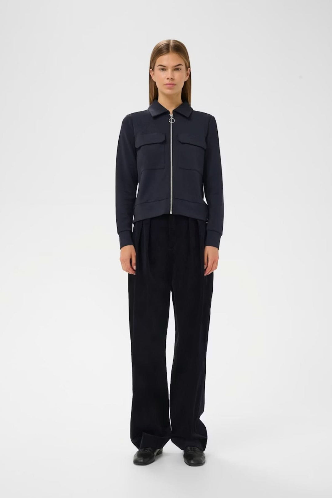 Veste à manches longues Beca avec fermeture éclair avant et poches poitrine sur mannequin en fond blanc. Chic et fonctionnelle.