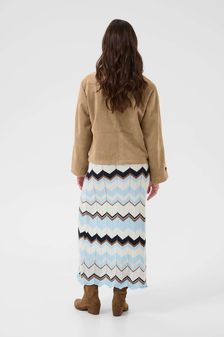 Veste décontractée Cala en suédine, vue de dos sur mannequin, portant une robe longue à motifs zigzag et des bottes marron.