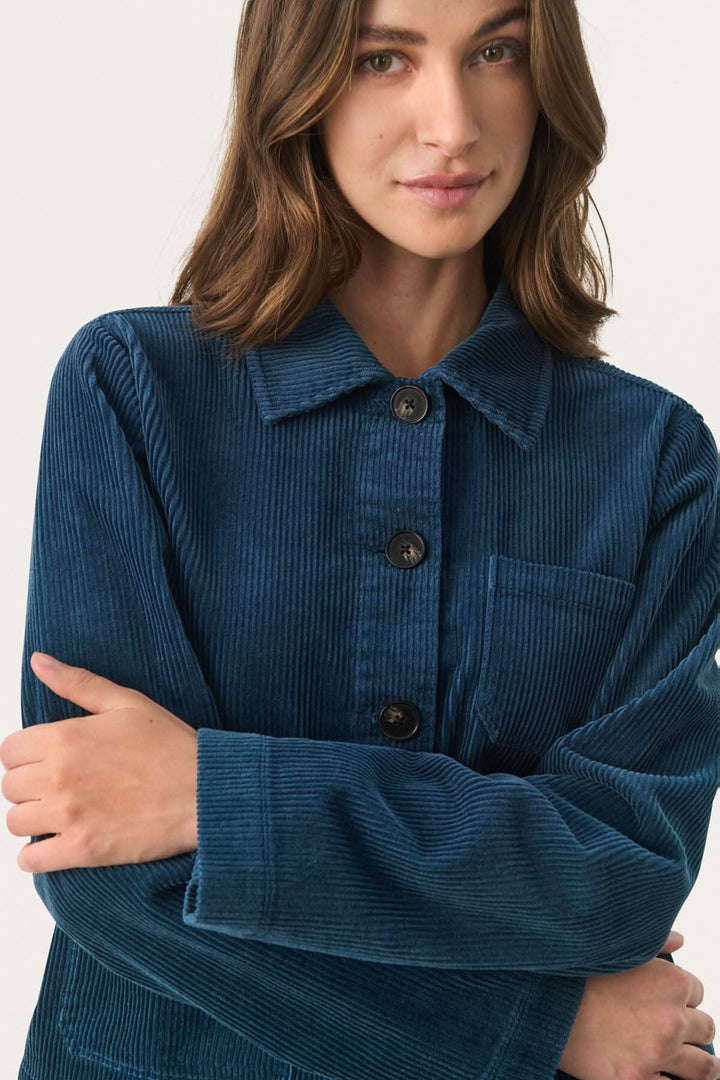 Veste en corduroy bleue avec col classique et boutons contrastants, ajoutant élégance et confort.