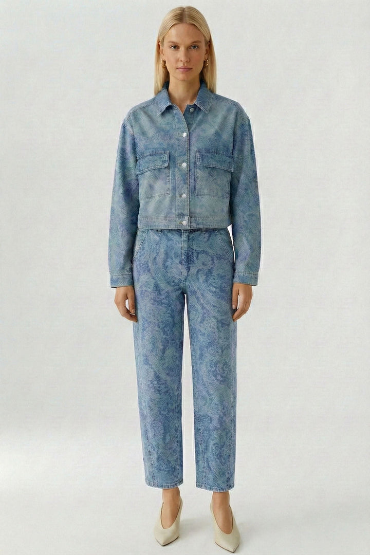 Modèle portant une veste en jean imprimée avec un motif cachemire, coupe courte et structurée, associé à un pantalon coordonné.