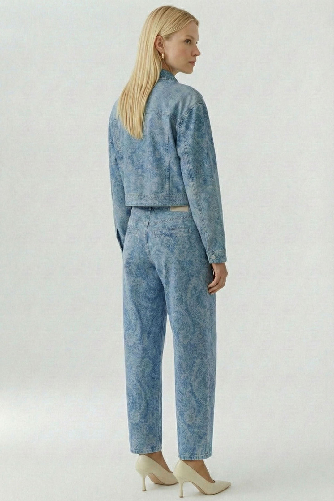 Veste en jean imprimée avec motif cachemire subtil, coupe raccourcie, vue de dos sur mannequin, allure moderne et chic.