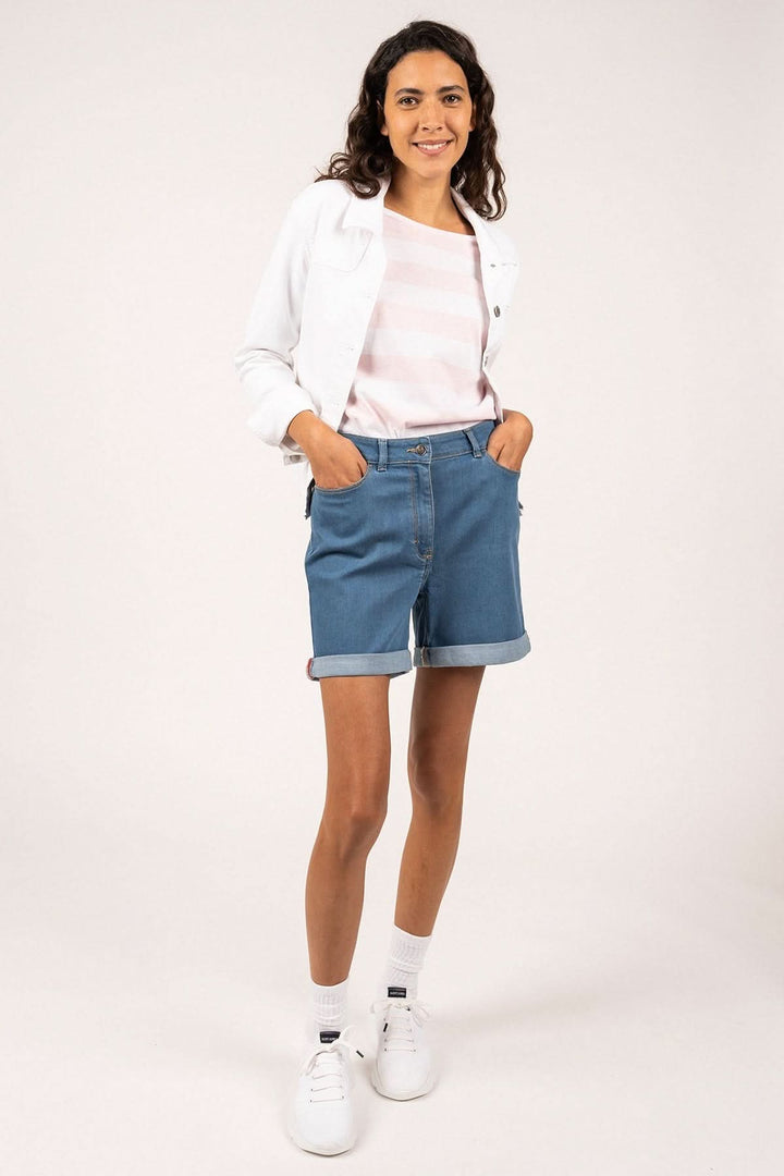 Femme portant une veste en toile de coton STE TEA avec un short en jean et des baskets blanches, chic et décontractée.