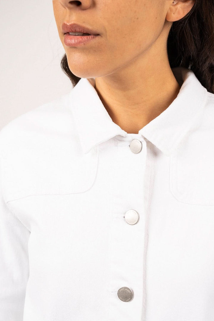 Veste en toile de coton STE TEA avec des boutons argentés sur fond neutre, inspirée des vêtements de travail pratiques et élégants.