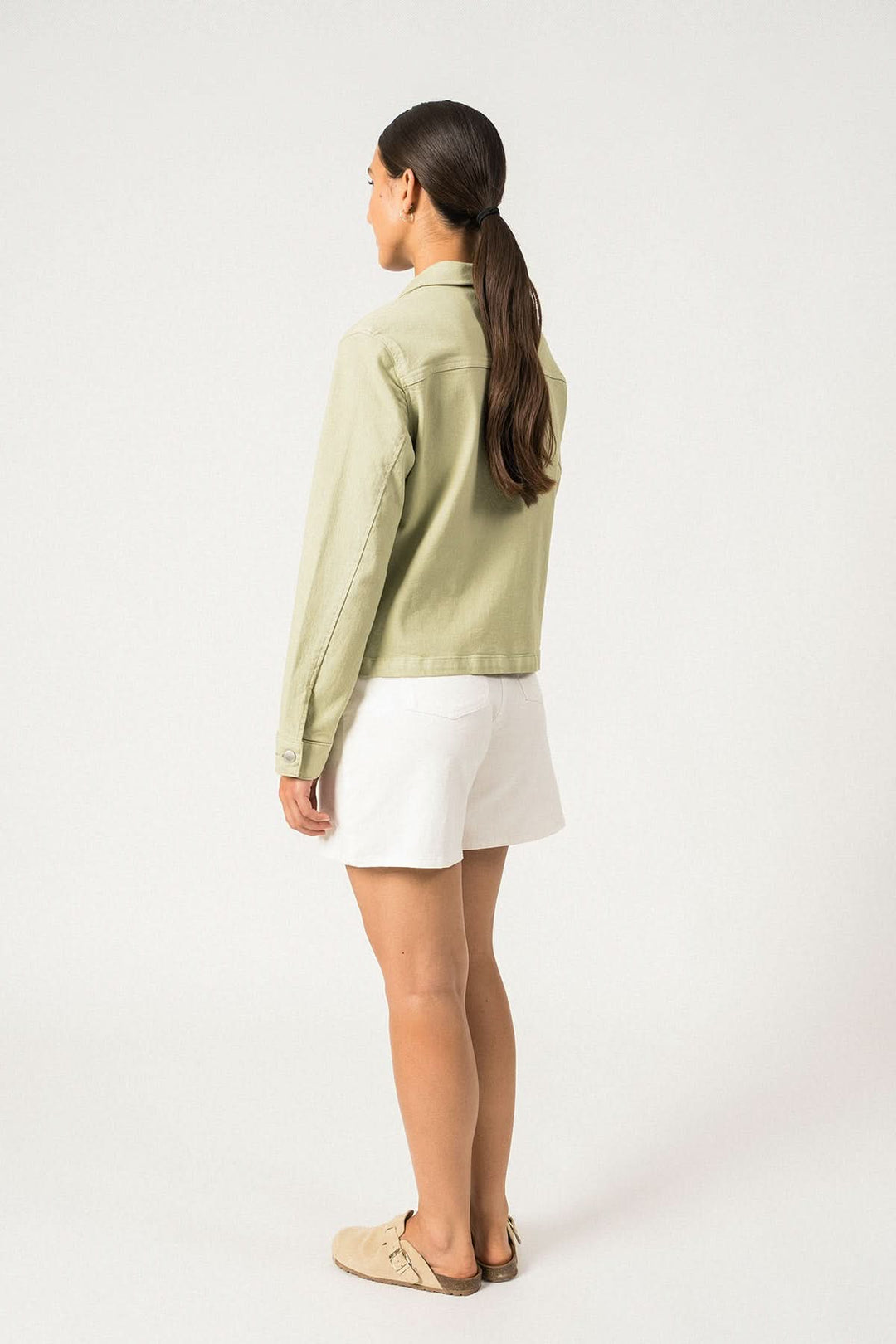 Veste en toile de coton STE TEA, vue arrière sur mannequin, associée à un short blanc.