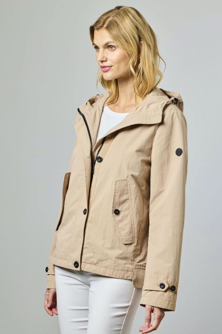 Femme portant une Veste légère à capuche utilitaire beige avec poches et fermeture à boutons pression.