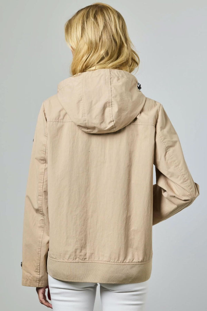 Femme portant une veste légère à capuche utilitaire beige, vue de dos, idéale pour la mi-saison avec design épuré et moderne.