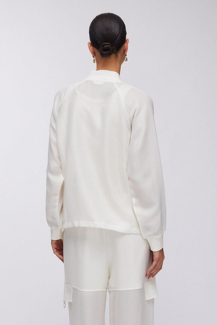 Veste légère à manches longues avec poches cargo en tissu blanc vue de dos, coupe ample et silhouette moderne.