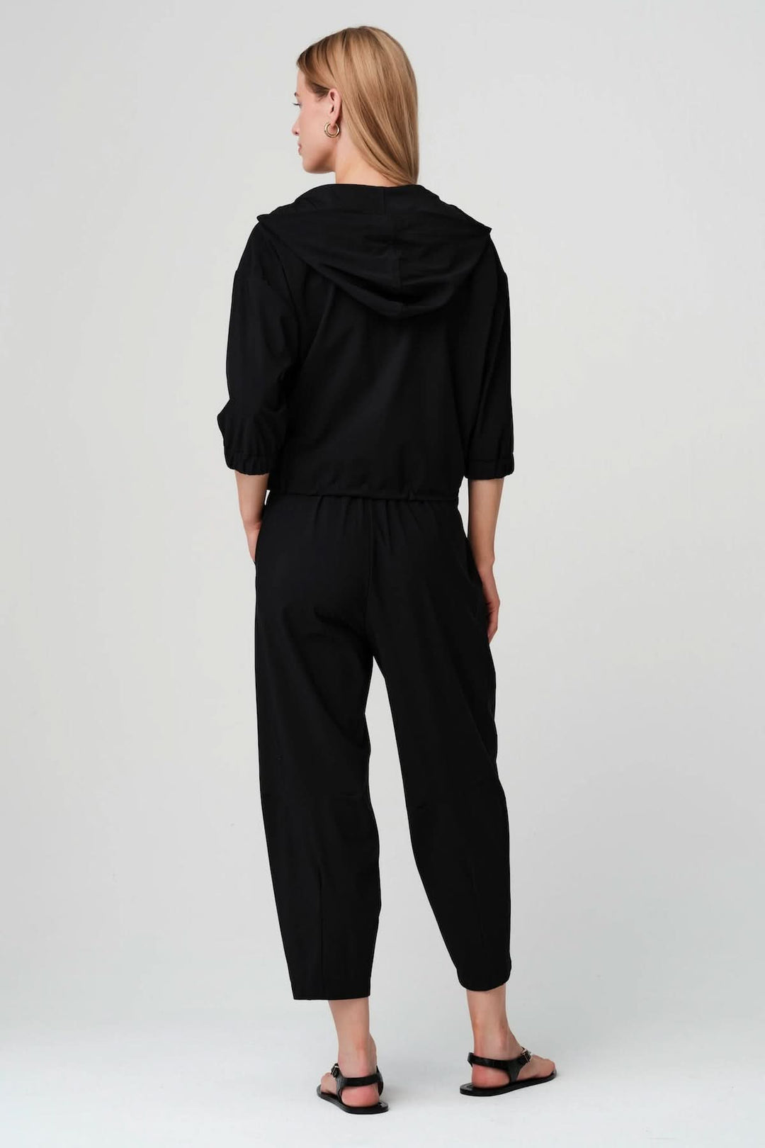 Vue arrière de la veste légère zippée à taille ajustable, modèle noir avec manches trois-quarts, cordon de serrage et col montant souple.