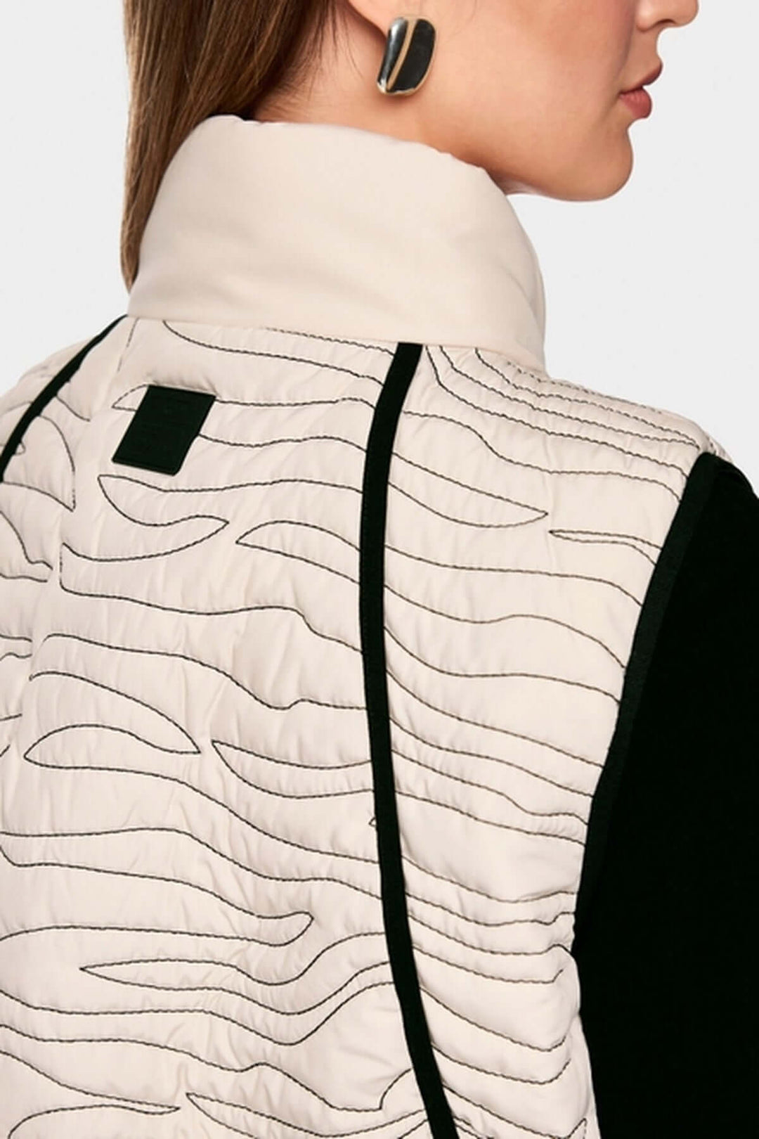 Veste matelassée avec surpiqûres ondulées et col montant pour chaleur et style moderne, vue arrière détaillée du motif.