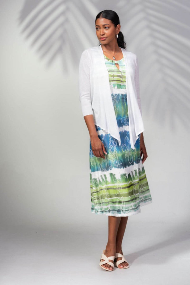 Femme portant une veste ouverte blanche sur une robe colorée, idéale pour une soirée estivale ou la mi-saison.