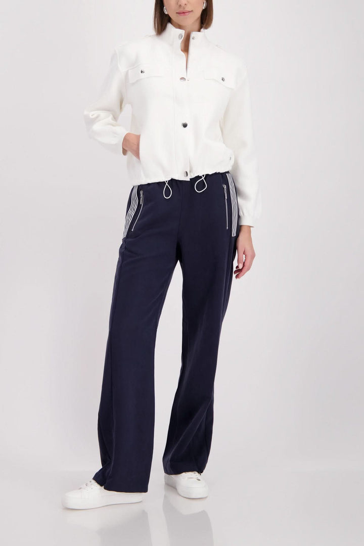 Femme portant une veste structurée à col montant, style contemporain et coupe courte, ajoutant une touche élégante et moderne à la tenue.