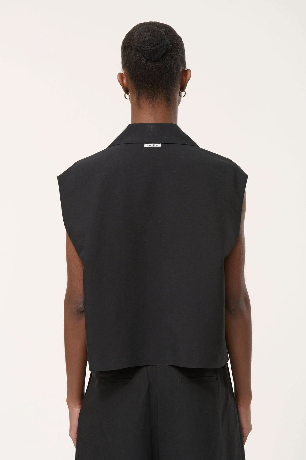 Dos d'une Veste tailleur Loric sans manches noire avec coupe droite et col tailleur à revers, créant une allure sophistiquée.