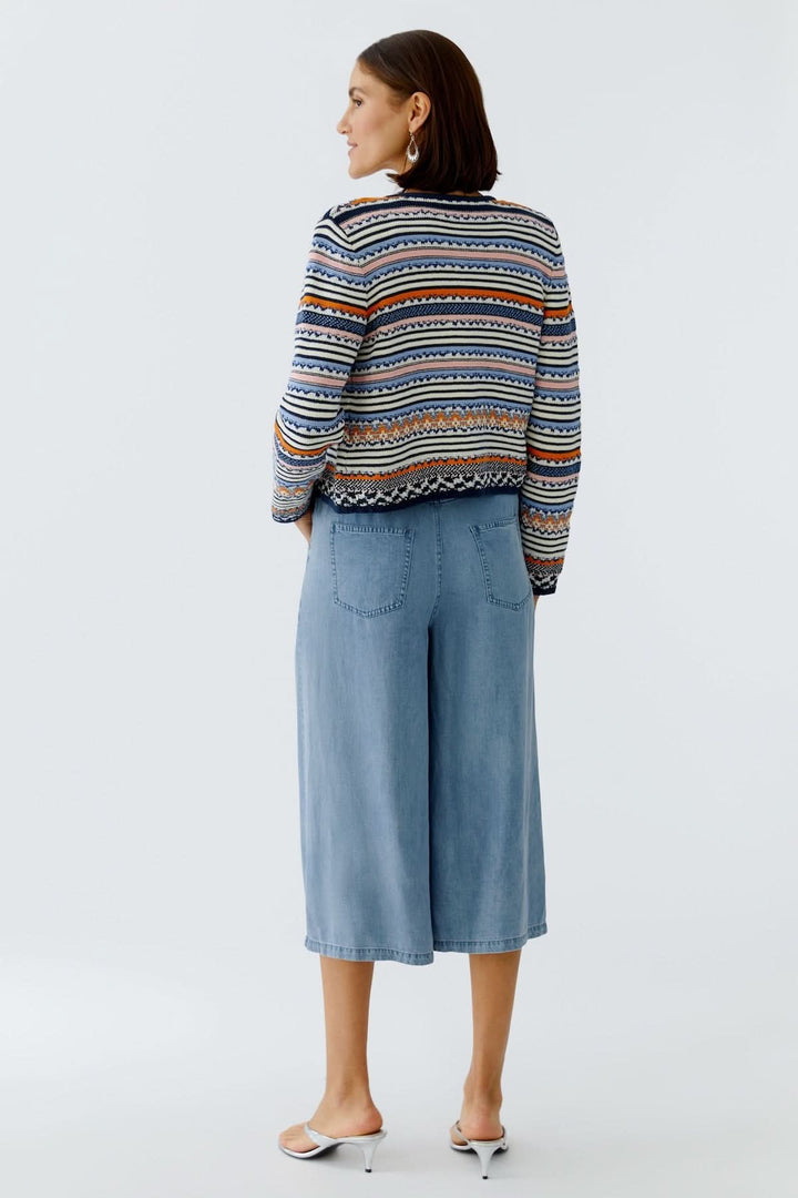 Femme portant une Veste tricot à motifs jacquard boutonnée élégante et originale, vue de dos, avec des motifs raffinés et colorés.
