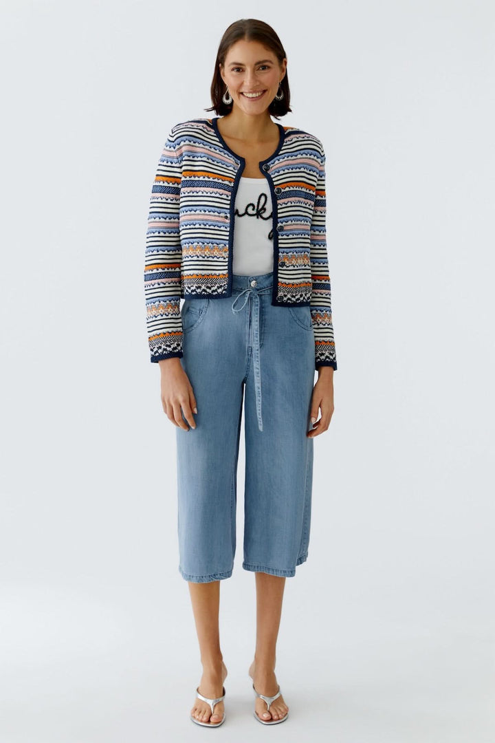 Femme portant une veste tricot à motifs jacquard boutonnée avec coupe ajustée, parfaite pour un style élégant et original.