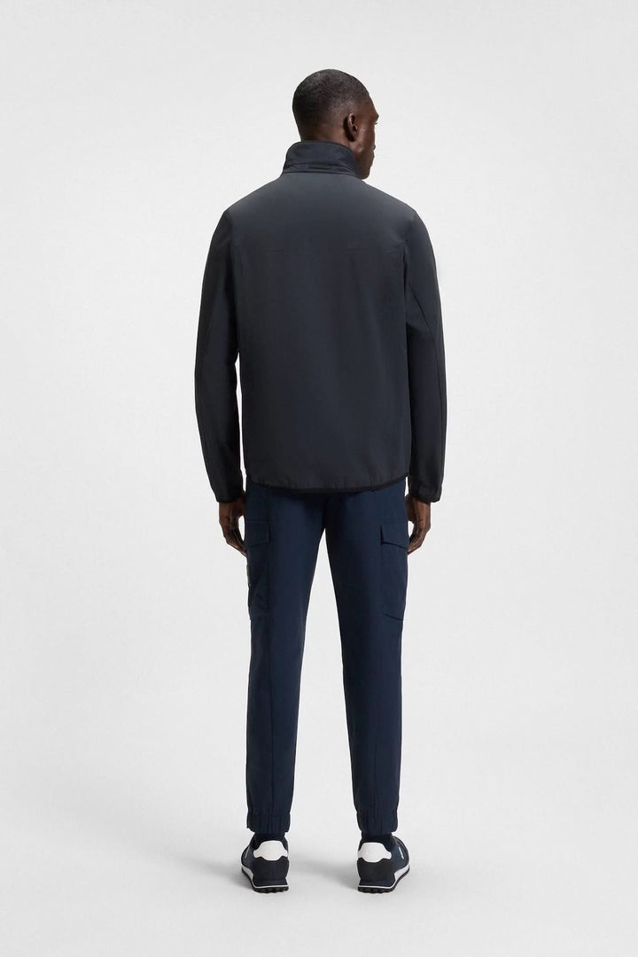 Veste urbaine légère vue arrière, idéale pour les journées fraîches, associée à un pantalon cargo bleu.