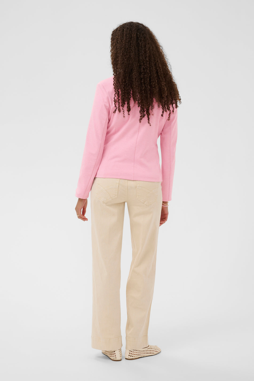 Vue arrière du Veston Anett rose élégant porté avec un pantalon beige, parfait pour un look professionnel et féminin.
