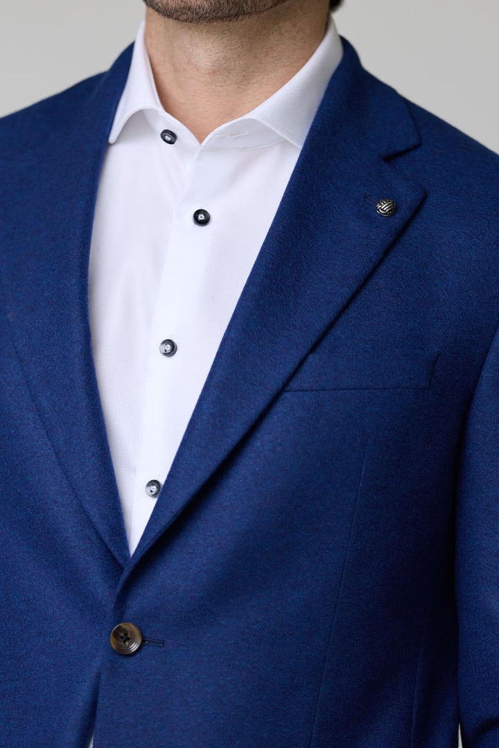 Homme portant le Veston DARWIN 100% Cachemire à deux boutons bleu élégant avec chemise blanche, style raffiné.