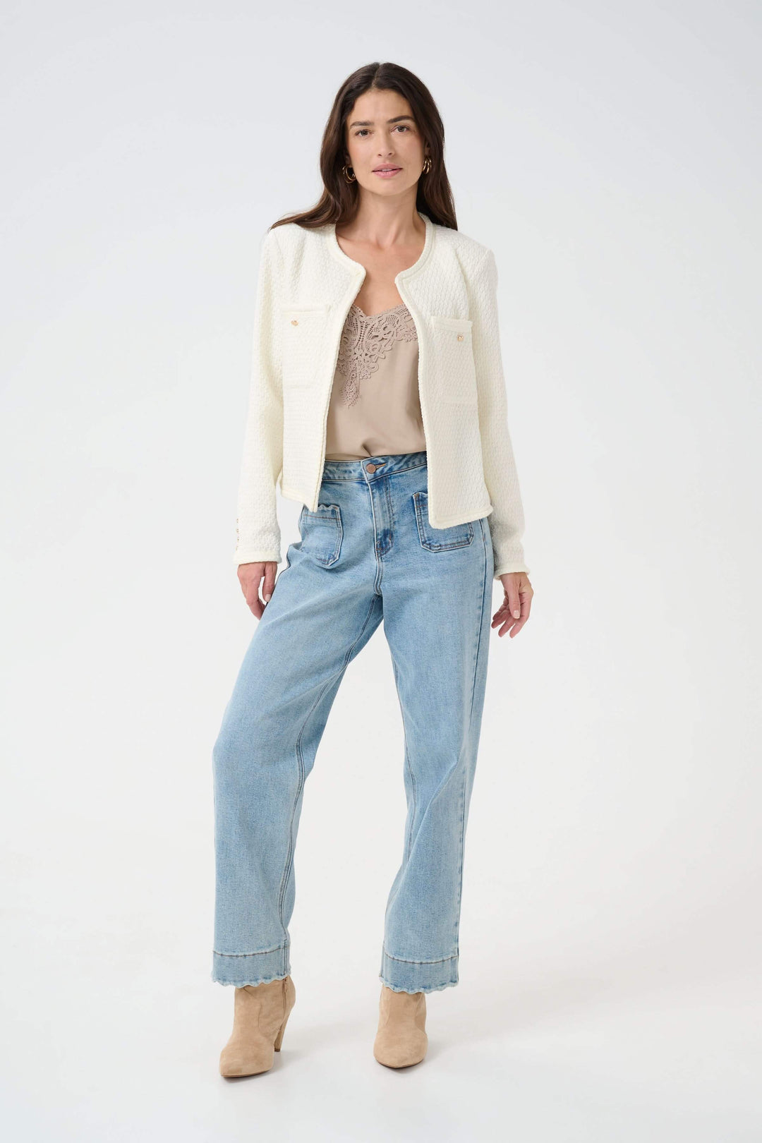 Femme portant un veston Janiah en tissu bouclé, jean décontracté, et bottines, style élégant.