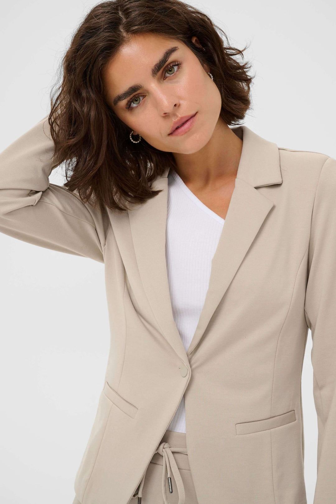 Femme portant le Veston Jenny beige, coupe ajustée, élégant pour un style quotidien.