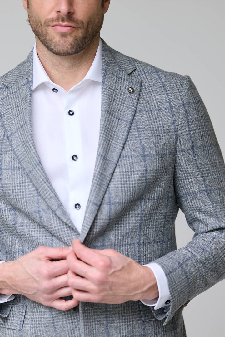 Homme portant un veston à carreaux moderne, coupe ajustée et élégante, parfait pour le bureau et les occasions spéciales.