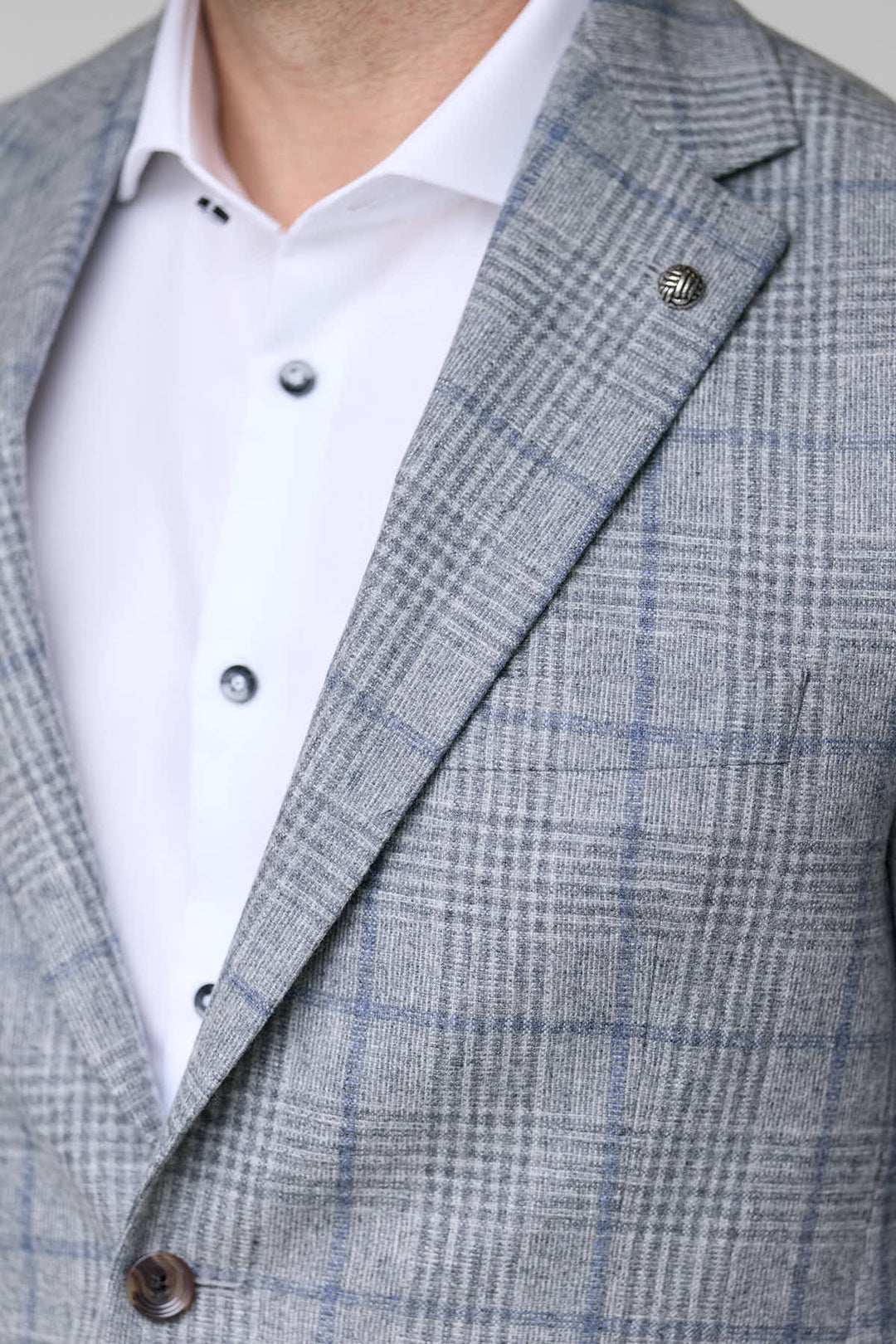 Homme portant un veston à carreaux moderne, coupe ajustée, élégant pour bureau et occasions spéciales.