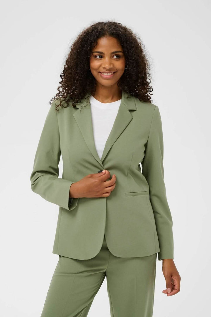 Femme portant un Veston à coupe droite vert pour un style élégant et professionnel, idéal pour le bureau et les occasions spéciales.