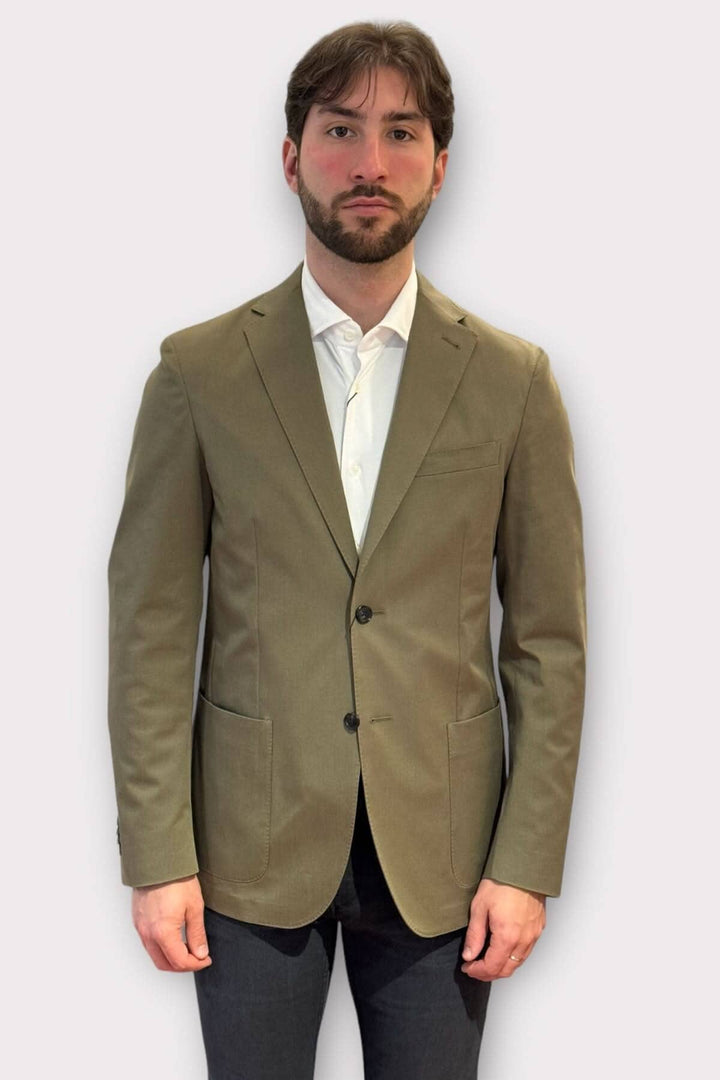 Homme portant un veston de coton kaki, offrant une allure élégante et polyvalente, idéal pour diverses occasions.