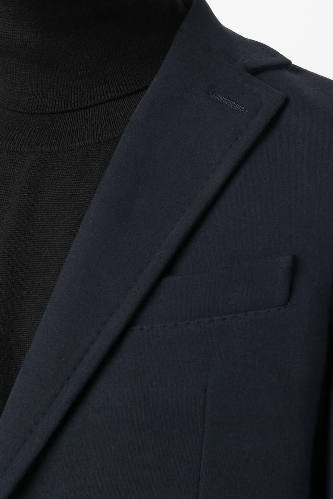 Homme portant un veston extensible de coton doux noir, col à revers avec œillet, pour un look élégant et décontracté.